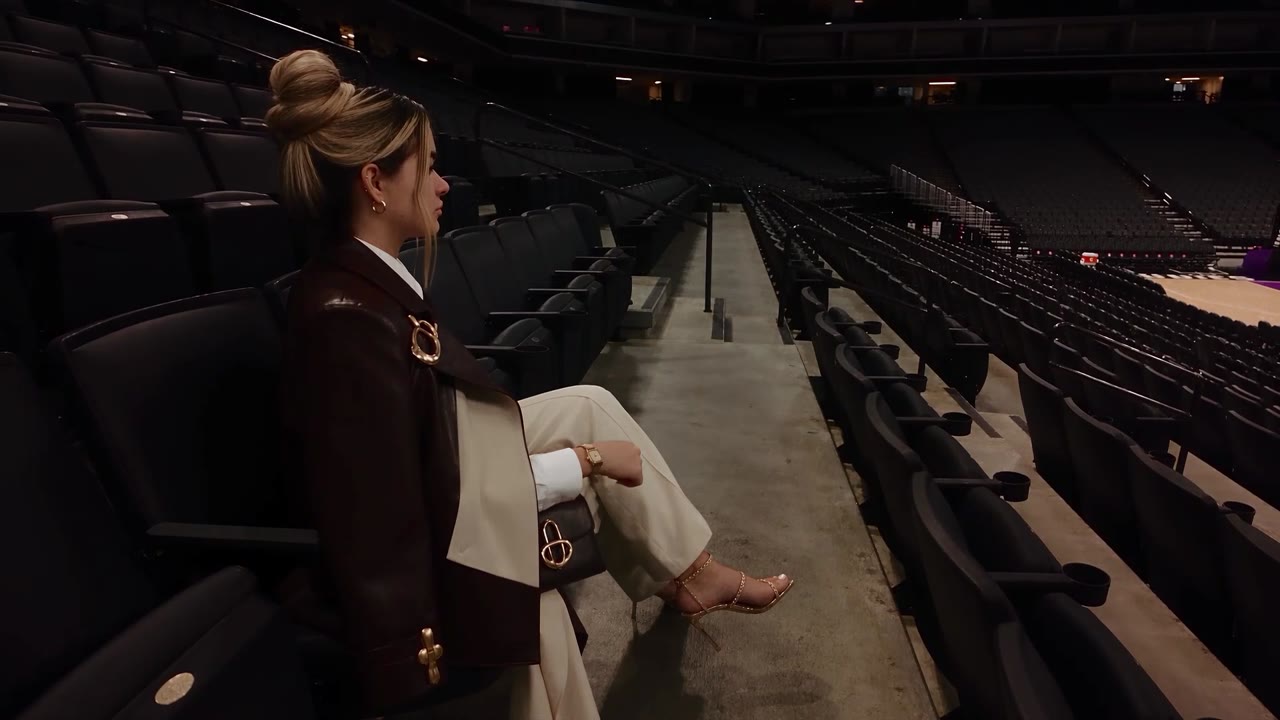 Jenni Ochoa, fundadora de Profit Picks, sentada en las gradas de una arena de basquetbol