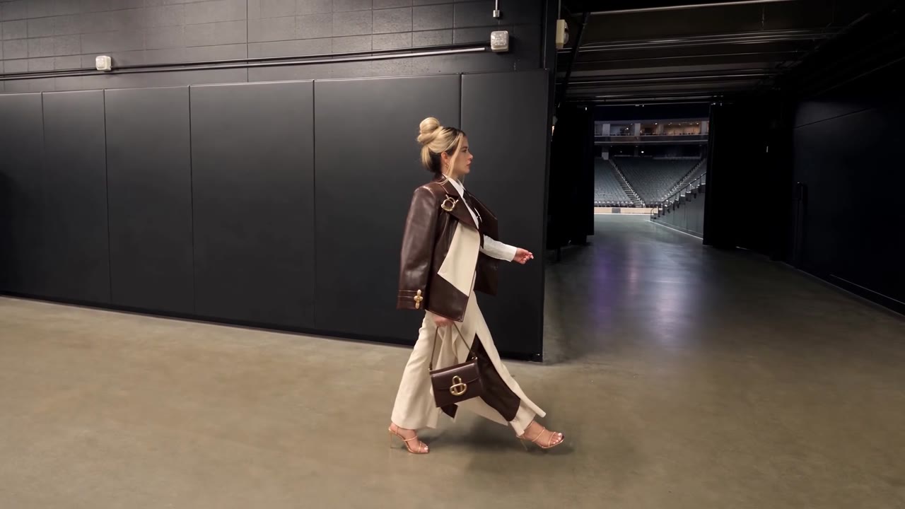 Jenni Ochoa caminando por el túnel de una arena de basquetbol